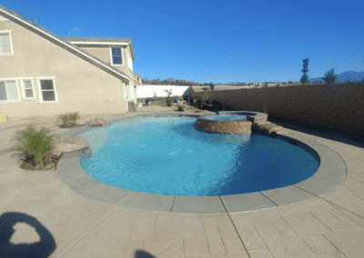 A swimming pool in a backyard with a waterfall.