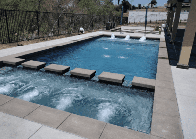 A swimming pool in a backyard with a waterfall.