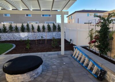 A backyard with a fire pit and landscaping.