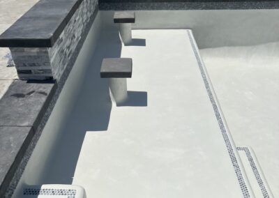 A swimming pool with a bbq and a grill.