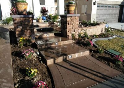 A front yard with steps and potted plants.