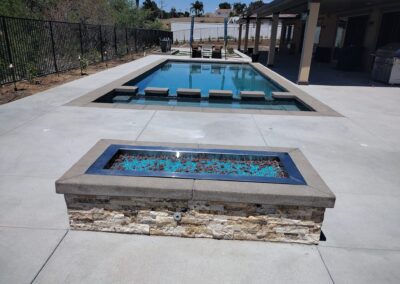 A pool with a fire pit next to it.